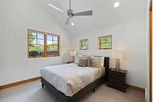 Bedroom with vaulted ceiling, multiple windows, recessed lighting, light colored carpet, and ceiling fan