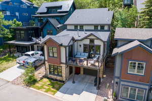 View of front of house featuring driveway, a shingled roof, stone siding, and a garage