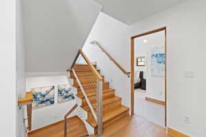 Staircase featuring wood finished floors and recessed lighting