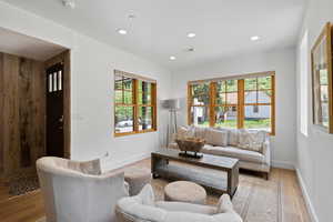 Living room with light wood-style flooring and recessed lighting
