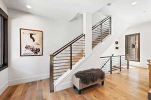 Staircase with recessed lighting and wood finished floors