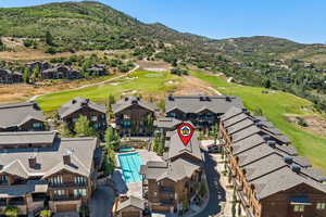 Aerial view of residential area with a golf course and a mountainous background