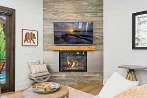 Living room with a glass covered fireplace and wood finished floors
