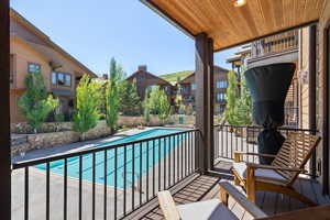 Balcony featuring view of pool area