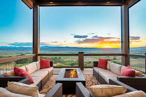 Deck featuring an outdoor living space with a fire pit and a mountain view