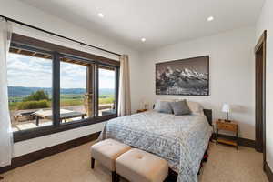 Carpeted bedroom with a mountain view and recessed lighting