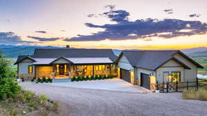 View of front of home with stone siding, a porch, concrete driveway, a garage, and a shingled roof