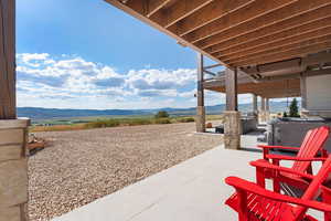 View of patio with a mountain view and a hot tub