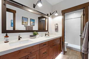 Bathroom featuring double vanity and a stall shower