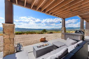 View of patio / terrace with an outdoor living space with a fire pit and a mountain view