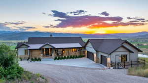 View of front of house with stone siding, a porch, a mountain view, and an attached garage