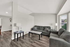 Living room featuring lofted ceiling, wood finished floors, and recessed lighting