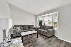 Living room featuring vaulted ceiling and wood finished floors