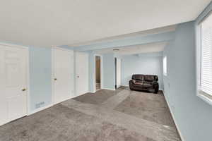 Carpeted living room featuring a textured ceiling