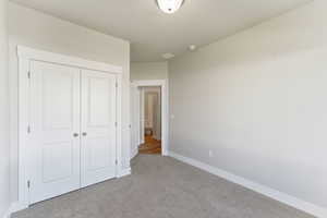 Unfurnished bedroom featuring carpet floors and a closet