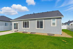Back of property with a fenced backyard, stucco siding, and a shingled roof