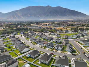 Aerial view of property and surrounding area with a mountainous background and nearby suburban area