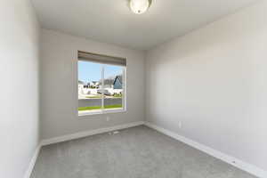 Spare room with light carpet and baseboards