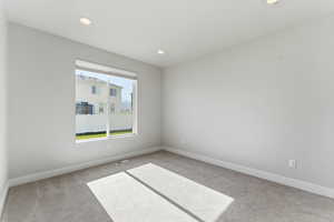 Carpeted empty room with baseboards and recessed lighting