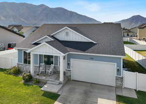 View of front of home with stone siding, board and batten siding, and a shingled roof