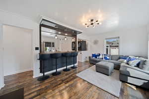 Living area with a chandelier, dark wood-style floors, and plenty of natural light