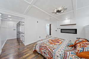 ADU Bedroom featuring a decorative wall, wood finished floors, recessed lighting, and coffered ceiling