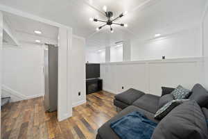 ADU Living area featuring a decorative wall, a chandelier, wood finished floors, and recessed lighting