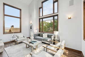 Living area featuring wood finished floors and a towering ceiling