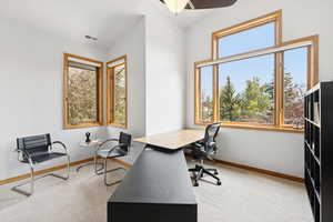 Carpeted office with ceiling fan and baseboards