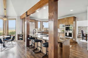 Kitchen featuring stainless steel appliances, recessed lighting, dark wood-style flooring, a breakfast bar area, and stone countertops