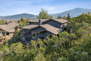 Back of property featuring a mountain view, a shingled roof, and a chimney