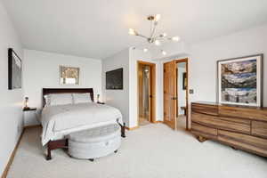 Bedroom featuring a chandelier and carpet floors