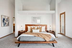 Carpeted bedroom featuring a towering ceiling, recessed lighting, and access to outside