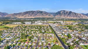 Aerial view of property's location with nearby suburban area and a mountainous background