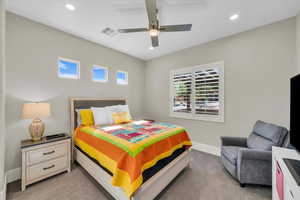 Bedroom with multiple windows, light colored carpet, recessed lighting, and ceiling fan