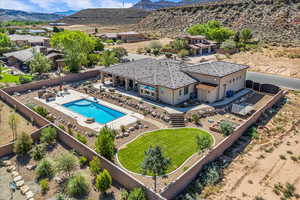 Aerial view of property and surrounding area featuring a pool area and a mountainous background
