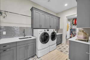 Laundry area featuring cabinet space, washing machine and clothes dryer, and light floors