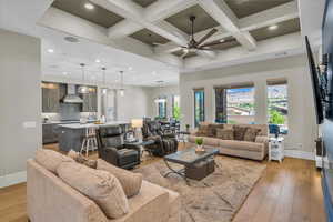 Living area with coffered ceiling, beam ceiling, recessed lighting, light wood-type flooring, and ceiling fan