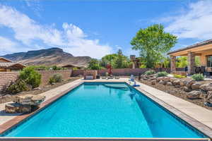 View of pool featuring a mountain view, a fenced backyard, and a patio
