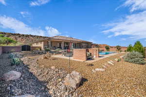 Rear view of property featuring a patio area and a tiled roof