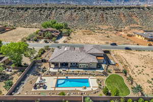 Aerial view of property and surrounding area featuring a pool area and a desert landscape