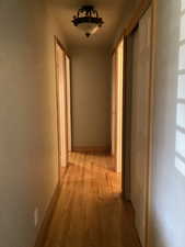 Hallway with light wood-style floors and baseboards