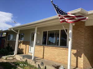 View of front facade featuring brick siding and covered porch