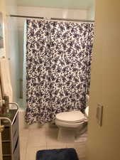 Full bath with tile patterned flooring and shower / bath combination with curtain