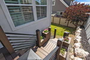 Wooden terrace with a fenced backyard