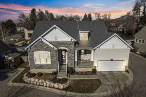Craftsman inspired home with stone siding, driveway, a shingled roof, and a porch