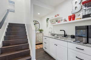Bar with stairway, dark wood finished floors, and recessed lighting