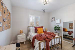 Bedroom with wood finished floors and baseboards