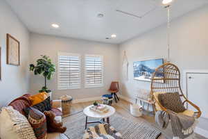 Living area with wood finished floors, recessed lighting, and attic access