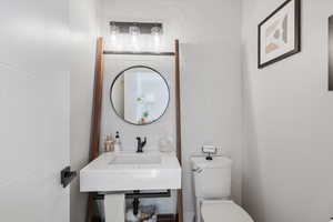 Bathroom featuring toilet and tile walls